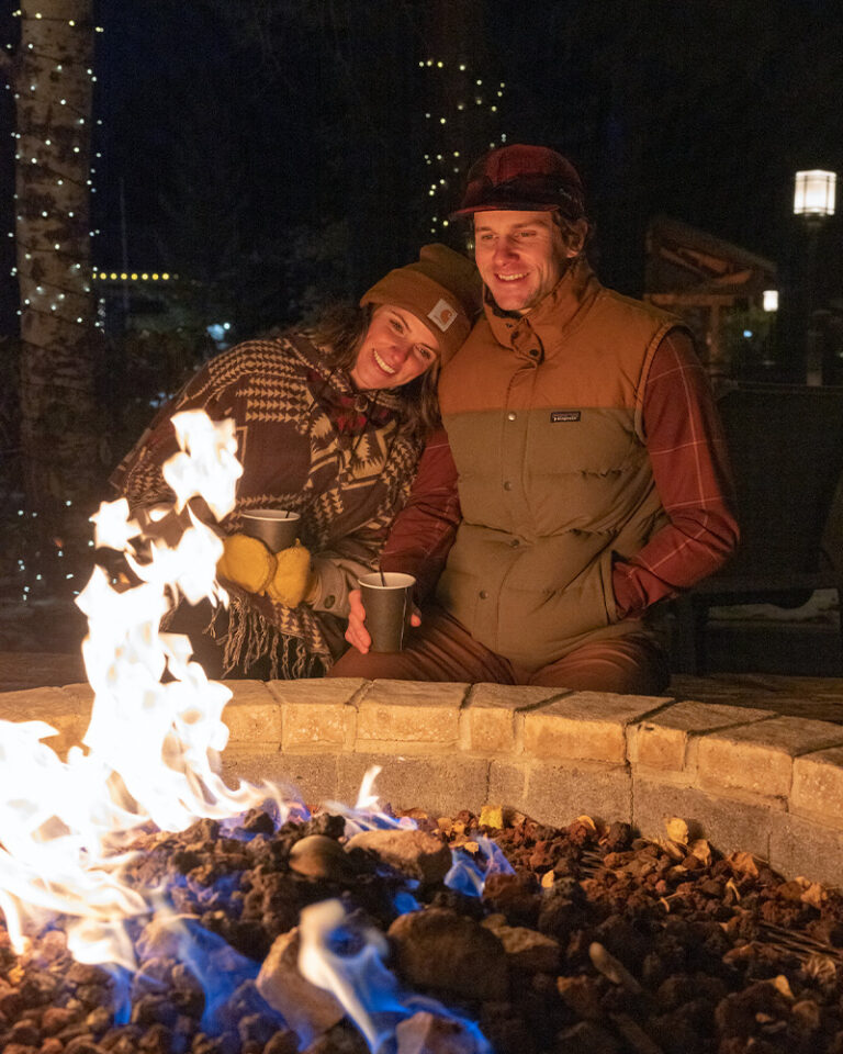 A couple sits by the fire at Seventh Mountain Resort near Bend, Oregon.