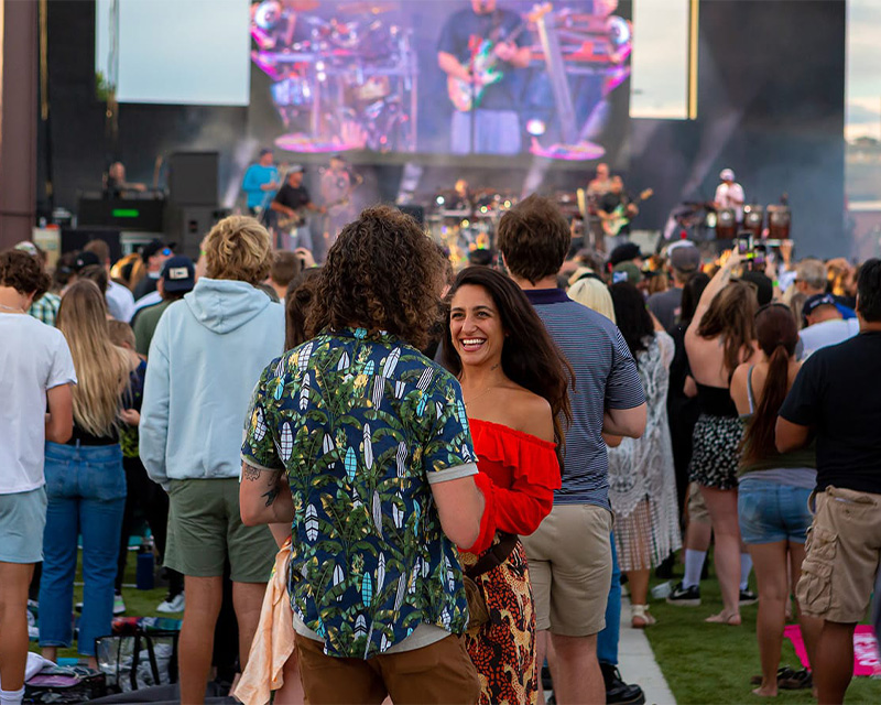 Two people stand together at a concert during Bend's summer concert series. 