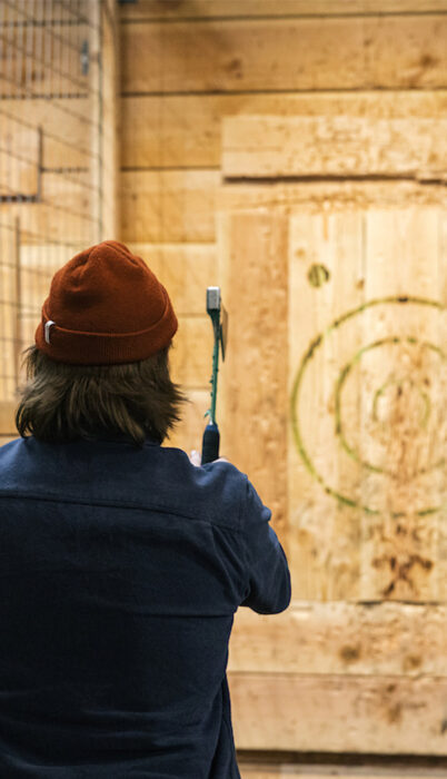 A man throws an axe at a bullseye at Unofficial Logging Co. in downtown Bend, Oregon.