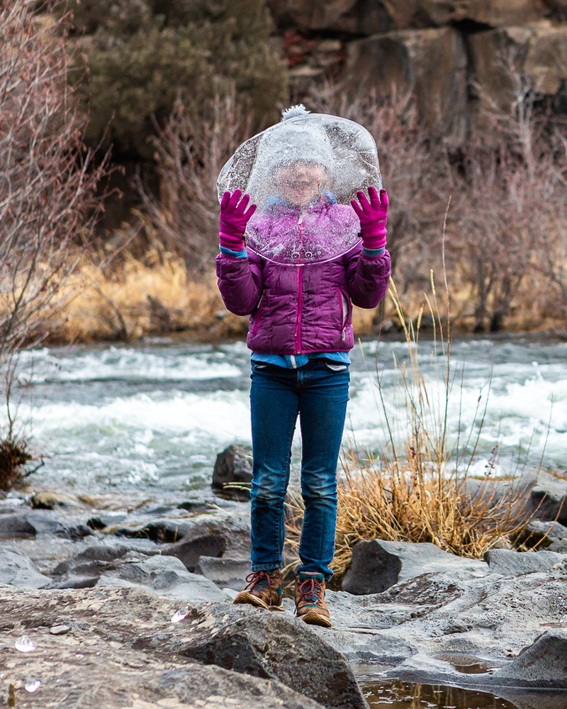 A child holds a piece of ice along the river in Bend, Oregon. 