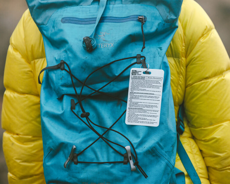 Leave No Trace tag hangs on the backpack of a hiker in Bend, Oregon.