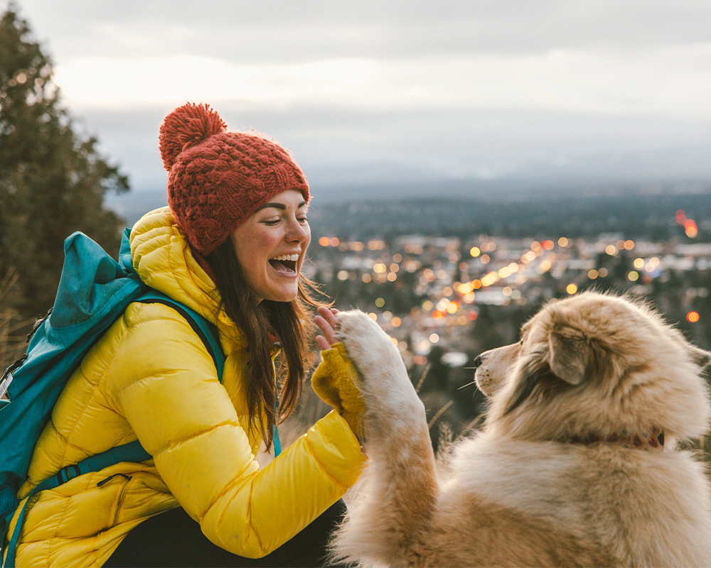 Hiker gives their dog a hi-five at the top of Pilot Butte in Bend, Oregon. 