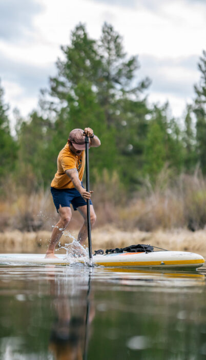 A guy paddle boards along the Deschutes River in Bend, Oregon.