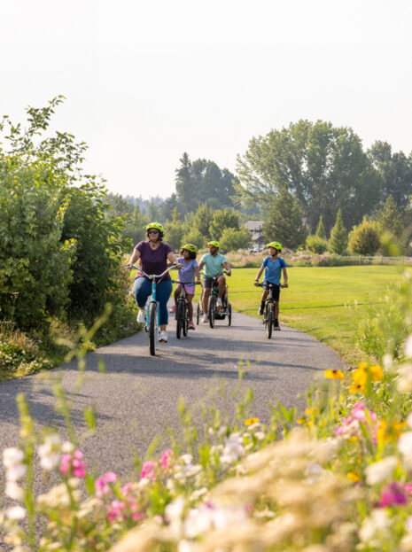 Family ride bikes along the greenway in Bend, Oregon's Old Mill District.