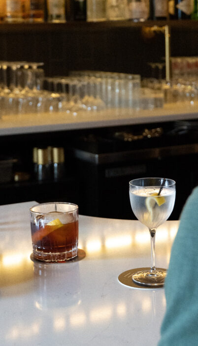 Zero-proof cocktails at Dear Irene in downtown Bend, Oregon, featuring a Path Less Taken mocktail on the bar beside a classic martini glass.”