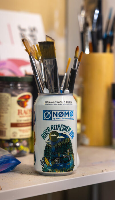 NØMØ Crux Fermentation can being used as an art supply holder for Spring Break Jake's paint brushes.